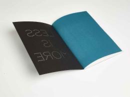 Chaque cahier est composé d’une sur-couverture noire ajourée par le procédé du micro-perçage qui révèle le message “LESS IS MORE”.